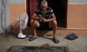 A Cuban man charges his cell phone using a solar panel during a power outage. (© picture alliance / ASSOCIATED PRESS / Ramon Espinosa)