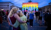 Mourners and rainbow colours projected onto the Brandenburg Gate in Berlin on the day after the attack. (© picture alliance/dpa/Christoph Soeder)