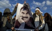 Barış çağrısının Diyarbakır'da dev ekranda yayınlanması esnasında ellerinde Öcalan posteriyle poz veren göstericiler. (© picture-alliance/ ASSOCIATED PRESS / Metin Yoksu )