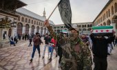 A masked opposition fighter with an HTS militia in the old city of Damascus. (© picture-alliance/dpa)