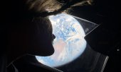 Astronaut Christina Koch gazing at the Earth before orbiting the Moon. (© picture alliance / Newscom / NASA)