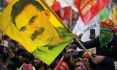 March 2018, Istanbul: a man holds up a flag showing the face of Abdullah Öcalan, the imprisoned leader of the PKK. (© picture alliance / ASSOCIATED PRESS Lefteris Pitarakis)
